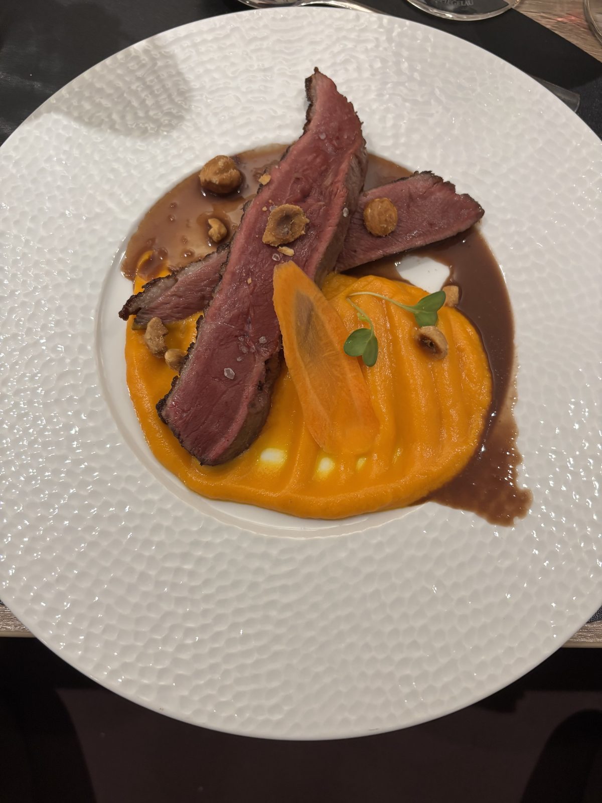 Magret de canard tranché, sauce chocolat noir, noisettes grillées et purée de patate douce
